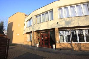 a building with a red door on a street at OKRĄGLAK Residence Sosnowiec in Sosnowiec