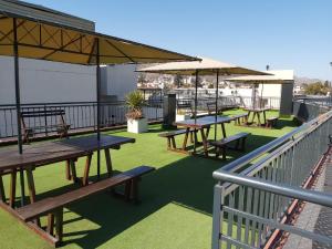 terraza con mesas de picnic y sombrillas en el balcón en Miralejos departamento suite premium en Villa Carlos Paz