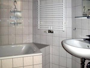 ein weißes Badezimmer mit einer Badewanne und einem Waschbecken in der Unterkunft Atelier Probst Salmannsweilergasse 22 in Konstanz