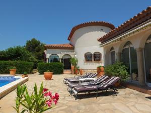ラメトリャ・デ・マールにあるVilla Leonore stunning 2bedroom villa with air-conditioning & private swimming poolの一団の家の前のラウンジチェア