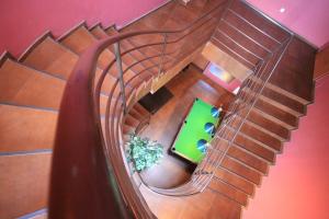 an overhead view of a spiral staircase with a green table at OKRĄGLAK Residence Sosnowiec in Sosnowiec