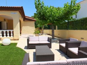 ラメトリャ・デ・マールにあるVilla Esperanza 4bedroom villa with air-conditioning & private swimming poolの中庭の木と椅子付きパティオ