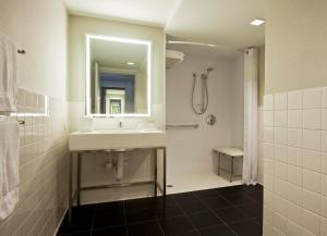 a white bathroom with a sink and a shower at Row NYC at Times Square in New York