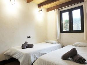 2 camas en una habitación con ventana en Villa Tranquila a charming 4bedroom villa with air-conditioning & private swimming pool, en L'Ametlla de Mar