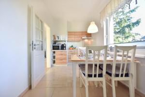 - une cuisine et une salle à manger avec une table et des chaises dans l'établissement Haus Thalia 3 - Seestern, à Ahlbeck