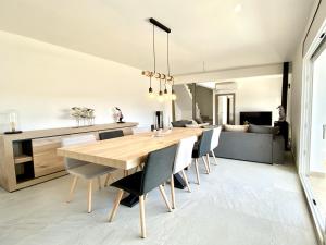 a kitchen and dining room with a wooden table and chairs at Villa Bouganvilla luxury villa with air-con, & private swimming pool ideal for families in L'Ametlla de Mar +130 photos