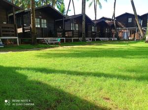 a building with a large shadow on the grass at Agonda Paradise in Agonda