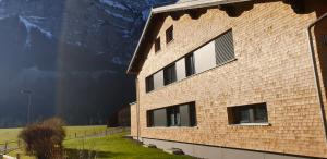 a brick building with a mountain in the background at Haus Feuerstein in Schnepfau