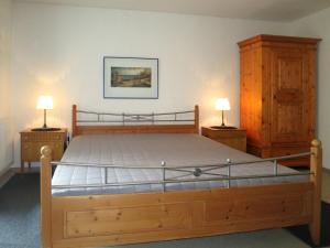 ein Schlafzimmer mit einem Holzbett mit zwei Nachttischen in der Unterkunft Atelier Probst Salmannsweilergasse 22 in Konstanz