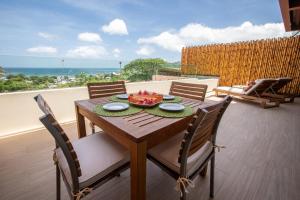 a wooden table with chairs and a bowl of fruit on it at La Santa Maria Resort in San Juan del Sur