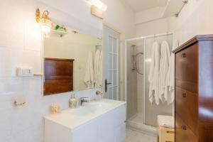 a white bathroom with a sink and a shower at Casa Amena in Minori