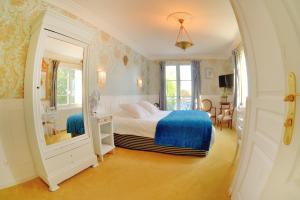 a bedroom with a bed and a mirror at Logis Hôtel & Restaurant Chateau de la Marjolaine in Essômes-sur-Marne