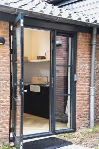 an extension to a brick house with sliding glass doors at In de bocht in Heiloo