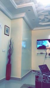 RESIDENCE MERCURE في داكار: غرفة مع تلفزيون على جدار مع لاب توب