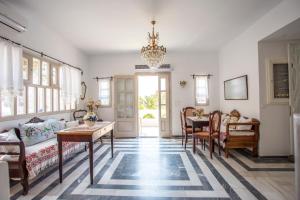 a living room with a chandelier and a table and chairs at TheArtemis Perissa in Perissa