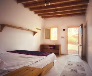 1 dormitorio con 1 cama y puerta corredera de cristal en Sheikh Mousa Bedouin Camp, en Saint Catherine