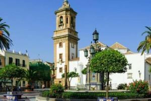 a building with a tower with a clock on it at Apartamento interior en el absoluto centro BA in Algeciras