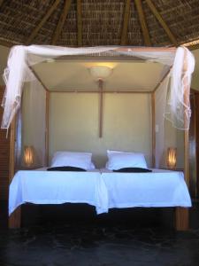 1 dormitorio con 2 camas con sábanas blancas en Kani Boutique Resort en Canavieiras