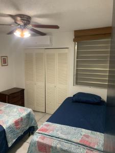 a bedroom with two beds and a ceiling fan at Caguax 206 in Cabo Rojo