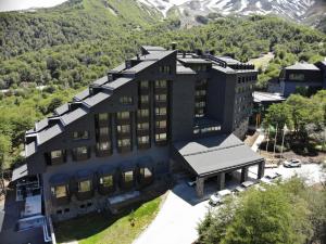 une vue aérienne sur un bâtiment avec des montagnes en arrière-plan dans l'établissement Hotel Termas Chillán, à Nevados de Chillan