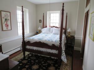 a bedroom with a bed and two windows at Cider House Bed and Breakfast in Waynesboro