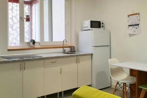 a kitchen with a white refrigerator and a table at Apartamento interior en el centro de Algeciras 2A in Algeciras