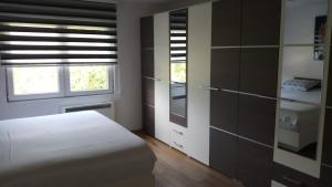 a bedroom with a white bed and a window at Vikend kuća Careva Ćuprija-apartman in Olovo