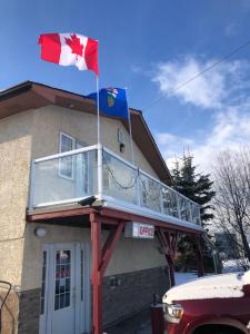 a building with two canadian flags on top of it at Alpine motel in Rocky Mountain House