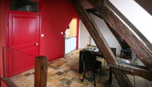 a red hallway with a table and a red door at Le Parvis in Chartres