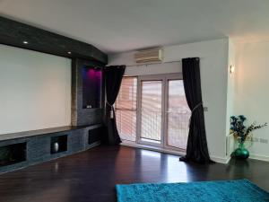 a living room with a large window and a tv at Stockton Heights, Warrington, Centrally Located Between Town Centre and Stockton Heath, High Speed Wifi, Cozy Stay in Warrington