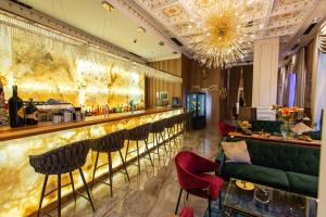eine Bar in einem Restaurant mit roten Stühlen in der Unterkunft Envy Hotel in Durrës