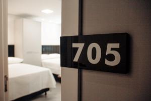 um quarto com duas camas e um sinal numa porta em Loft com vista para Vila Germânica 705 em Blumenau