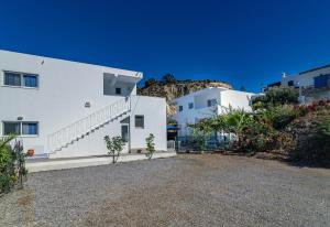 una casa con paredes blancas y escaleras en una colina en Mediterraneo Apartments, en Archangelos