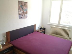 a bedroom with a bed with a purple blanket at "IDEAL" - für Zwei in Berlin