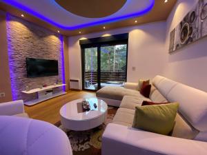 sala de estar con muebles blancos y TV en Apartment Crystal, en Zlatibor