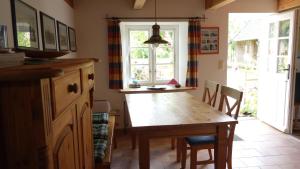 a kitchen with a wooden table and chairs and a window at Haus-Falkenberg-1 in Tating