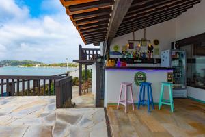 a bar on a deck with a view of the water at Vila Bela-Emília in Búzios
