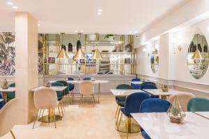 a restaurant with white tables and blue chairs at CasaSur Recoleta in Buenos Aires
