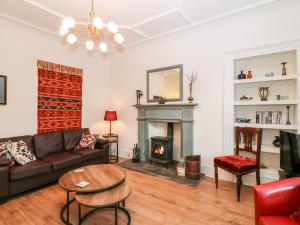 uma sala de estar com um sofá e uma lareira em George Cottage em Blairgowrie