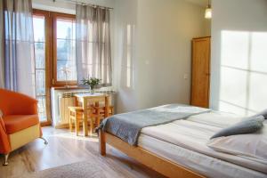 1 dormitorio con 1 cama, 1 silla y 1 mesa en DW Pod Jaworami - relaks w SPA - jacuzzi, sauna na wyłączność, en Białka Tatrzanska