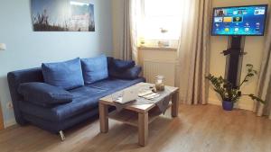 a living room with a blue couch and a coffee table at Ferienwohnung Emmely in Binz