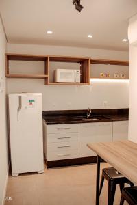uma cozinha com um frigorífico branco e uma mesa em Loft próximo a Vila Germânica 706 em Blumenau