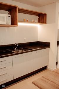 uma cozinha com um lavatório e um micro-ondas em Loft próximo a Vila Germânica 706 em Blumenau