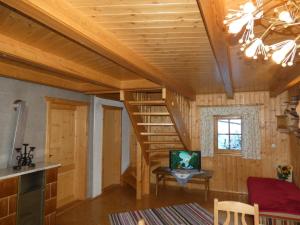 a room with a spiral staircase in a log cabin at Almhütte Seeberg in Turnau