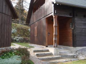 ein Holzgebäude mit einer Treppe, die zu einer Tür führt in der Unterkunft Almhütte Seeberg in Turnau