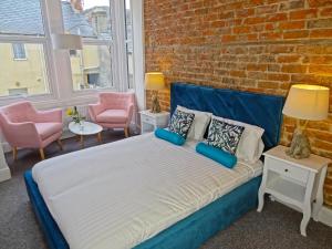 una cama en una habitación con una pared de ladrillo en Sea Coast Apartment by Seaside Llandudno, en Llandudno