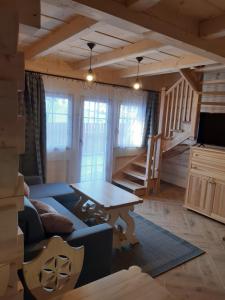 uma sala de estar com um sofá e uma mesa em Górska Chata Pod wyciągami Remiaszów i Jankulakowski Skibus pod domkami em Białka Tatrzanska