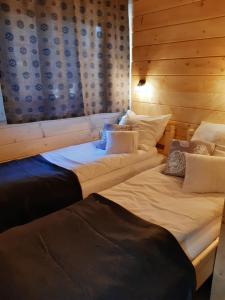 2 camas en una habitación con paredes de madera en Górska Chata Pod wyciągami Remiaszów i Jankulakowski Skibus pod domkami en Białka Tatrzanska