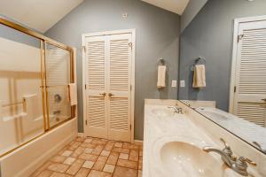 een badkamer met een bad, een wastafel en een douche bij Legacy at Thousand Hills in Branson