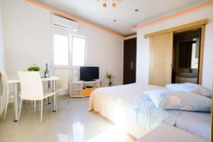 a bedroom with a bed and a desk and a television at Lara Apartments in Makarska